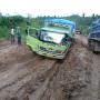 We don\'t see it, but there were 2 men underneath the green truck trying to dig out surplus mud.
